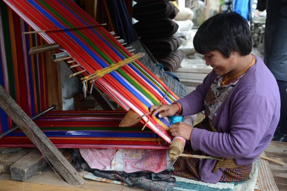 A woman weaving traditional handloom for making Kira and Gho (the national dress of Bhutan).